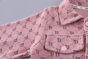 Detail of pink corduroy toddler jacket with letter pattern and front flap pocket