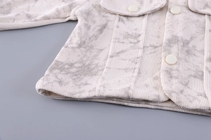 Detail of baby corduroy jacket with marble print, large white buttons and flap pocket