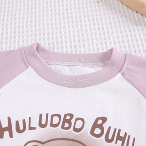 Détail d'un t-shirt enfant avec manches raglan et motif ours de dessin animé mignon