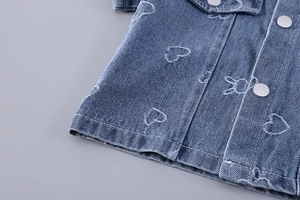 Detail of denim fabric featuring cute rabbit and heart prints with silver metal buttons
