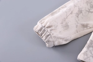 Detail of elastic ribbed cuffs on a beige marble print corduroy jacket for girls