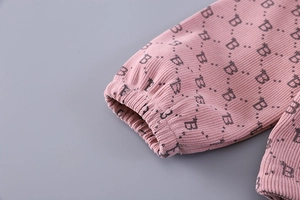 Detail of pink corduroy sleeve with elastic cuff and letter B polka dot pattern print