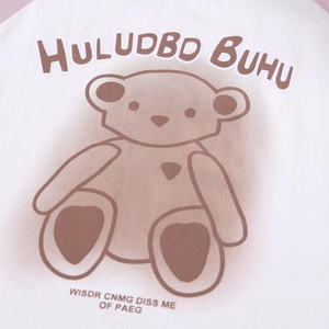 Détail d'un t-shirt en coton doux avec un imprimé d'ours de dessin animé brun mignon