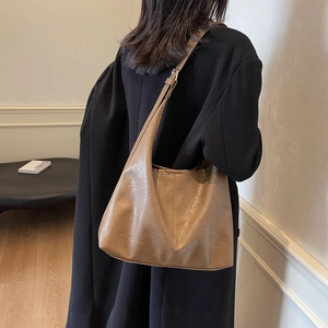Brown vintage large capacity leather tote bag worn by model in a minimalist setting