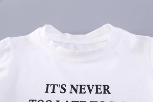 Detail of soft white cotton t-shirt with ribbed crew neck and black slogan print