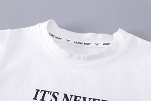 Detail of white cotton t-shirt featuring round neckline and black slogan print