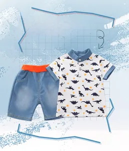 Detail of boys' polo shirt set featuring navy dinosaur prints and orange waist short