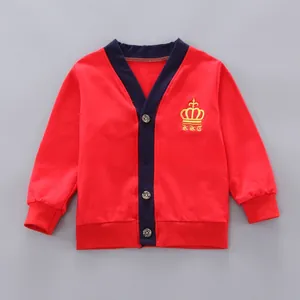 Detailed view of red children's cardigan with navy trim and gold crown embroidery