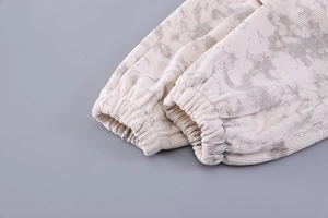 Detail of ribbed knit cuffs with beige and gray tie-dye pattern on kids clothing