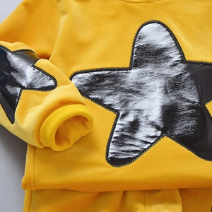 Detail of yellow velvet kids hoodie showing star print and soft ribbed cuffs