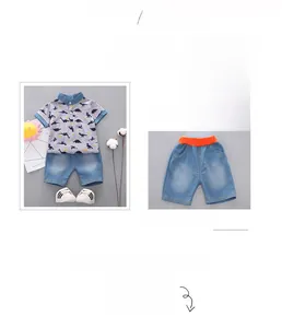 Detail of boys summer set with dinosaur print polo shirt and blue cotton blend shorts