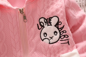 Vue détaillée du pull en maille rose avec broderie lapin et textures en losanges