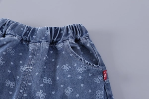 Détail du short en jean fille avec motif nœud, taille élastique et étiquette 80