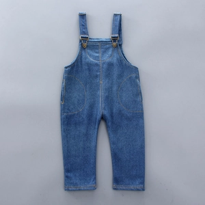 Detail of dark blue denim overalls with adjustable metal buckles and side pockets