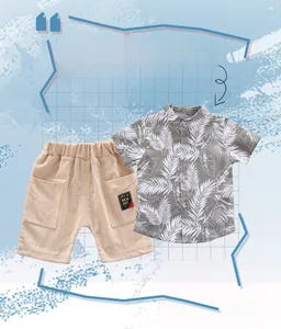 Detail view of boys' leaf print shirt and beige cotton shorts with woven patch