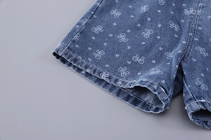 Détail d'un short en jean pour fille avec imprimés nœuds et finitions de couture soignées