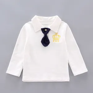 Detail of white cotton polo shirt featuring gold crown embroidery and navy blue tie