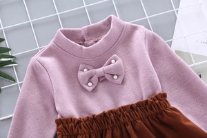 Detail of knit sweater with pearl bow and brown corduroy skirt for girls clothing set