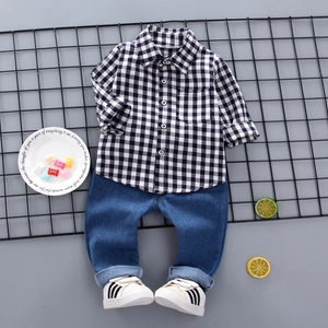 Piatto di camicia a scacchi per bambini con jeans e scarpe da ginnastica bianche su rete