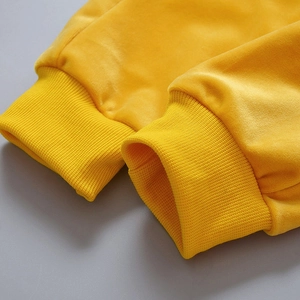 Detailed macro view of yellow velvet sleeve with elastic ribbed knit cuffs on kids' outfit