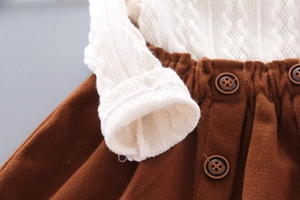 Detailed texture of cable knit sweater and brown corduroy skirt with decorative buttons