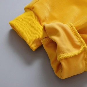 Close-up of bright yellow velvet fabric with ribbed cuffs on hooded children's wear