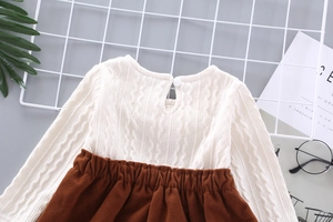 Flat lay of girl's knit dress set featuring cream cable sweater and brown skirt details