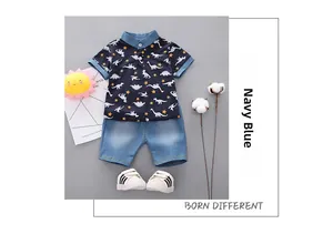 Detail of navy blue dinosaur print polo shirt with matching denim style shorts set
