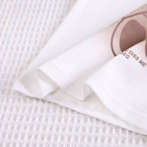 Détail du tricot de coton blanc avec imprimé dessin animé marron et couture durable