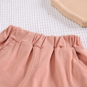 Détail de short en coton pour bébé avec taille élastique et poches latérales rose