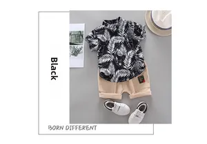 Detail of boys summer set with tropical leaf print shirt and beige shorts with logo patch