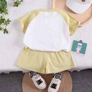 Détail à plat de l'ensemble coton enfant avec t-shirt raglan et short jaune assorti