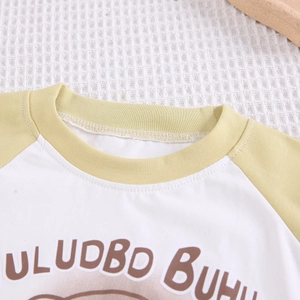 Détail des manches raglan et de l'encolure côtelée sur le t-shirt d'été en coton pour bébés