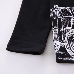 Détail d'un sweat enfant noir en coton avec coutures plates et imprimé camion blanc