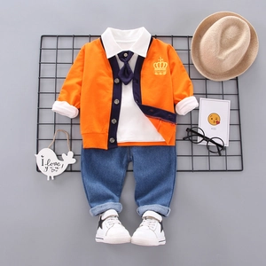 Three-piece boy's fashion set featuring orange cardigan, white shirt and denim jeans