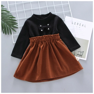 Girls' knitted sweater and brown pleated skirt set with a black bow and pearl details
