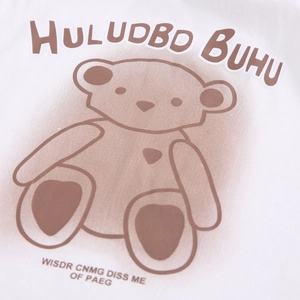 Gros plan d'un ours en peluche et texte imprimé sur un t-shirt blanc pour enfants