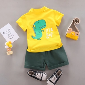 Flachbild von gelbem Polo-Shirt mit Dinosaurier-Druck und grünen Shorts für Kleinkinder