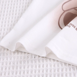 Détail de la double couture sur l'ourlet d'un t-shirt blanc en coton pour enfants
