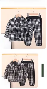 Ensemble veste épaisse et pantalon pied-de-poule noir et blanc pour garçons à plat