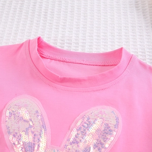 Détail du t-shirt rose pour fille avec oreilles de lapin à paillettes et col rond lisse