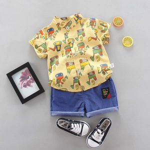 Set estivo bimbo con camicia gialla a cartoni animati e pantaloncini blu navy su grigio