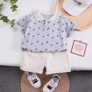 Boys summer two-piece outfit featuring grey palm print polo shirt and ivory shorts