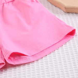 Gros plan du short rose montrant les détails de couture double et la texture du tissu