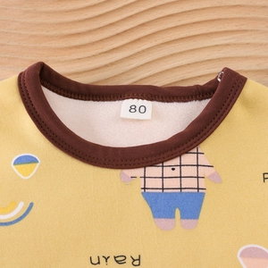 Detail of yellow kids' thermal underwear with soft fleece lining and cartoon print