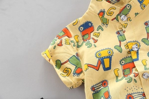 Dettaglio camicia gialla per bambini con motivi di veicoli da cantiere e colletto coreano