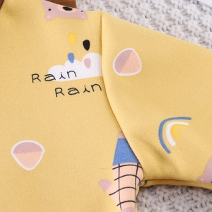 Close-up of thick yellow knit children's thermal top with cute cartoon bear and rainbow print
