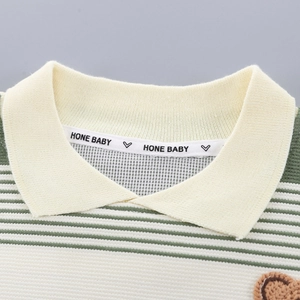 Detail of baby striped polo shirt collar with teddy bear embroidery and inner branding
