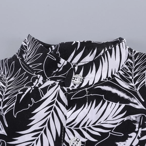 Macro detail of tropical leaf print fabric and decorative buttons on a boy's shirt