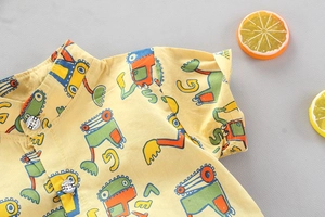 Dettaglio camicia bimbo in cotone giallo con stampe di scavatrici e bottoni bianchi